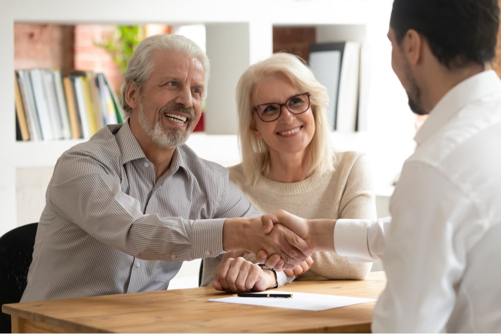 satisfied mature customers shake hand